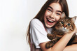 © Ольга Лукьяненко - girl with joyful expression hugging her tabby cat isolated on white background copy space