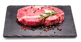 Fototapeta  - Raw ribeye steak with pepper corns and rosemary on graphite serving board isolated on white background.