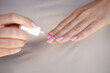 Nail Care And Manicure. Closeup Of Beautiful Female Hands Applying Transparent Nail Polish On Healthy Natural Woman's Nails