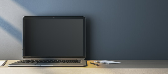 Close up of empty computer monitor on simple wide wooden desk. Blue wall background. Workplace concept. Mock up, 3D Rendering.
