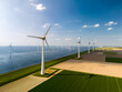Serene wind farm in Flevoland, the Netherlands. Rows of majestic windmills gracefully turning in harmony, harnessing the power of the wind to generate renewable energy