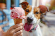 Pink strawberry ice cream in cone being held by human with panting terrier dog in blurry background