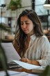 © Jorge Ferreiro - Woman Reading Paper at Desk