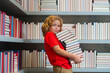 School and education concept. Child reads books in the library. Schoolkid with book in school library. Kids literature for reading. Learning from books. School education and clever talented pupil.