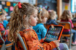 © alenagurenchuk - A young female child sitting in a chair while engaging with a tablet device