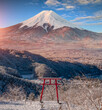 Red Japanese Torii pole, Fuji mountain and snow in Kawaguchiko, Japan. Forest trees nature landscape background in winter season.