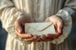 Close-up of a woman's hands presenting a vintage envelope, representing intimate communication