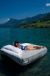 Beautiful booty girl enjoying the water rest. Water mattress concept. Sweet dreams. Sexy woman on Summer rest. Fit model in sexy bodysuit or swimsuit floating in the lake water.