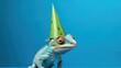 Funny chameleon with birthday party hat on blue background.