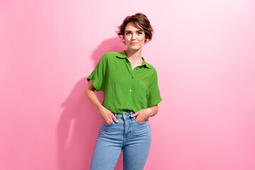 Canvas Print - Photo of positive adorable young woman dressed green shirt hands arms pockets isolated pink color background