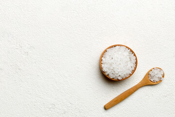 Wall Mural - A wooden bowl of salt crystals on a wooden background. Salt in rustic bowls, top view with copy space