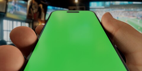 Wall Mural - Smartphone with green screen in sports bar, perfect for app demos