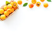 Fresh raw apricots in basket on white background top view copy space, pattern with leaves