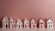 Paper houses on empty pink background with copy space 