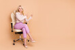 Full body photo of nice retired female sit office armchair point empty space wear trendy formalwear isolated on beige color background