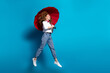 Photo portrait of nice young lady jump look empty space hold umbrella wear trendy white garment isolated on blue color background