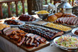 Table laden with barbecue ribs, brisket, pulled pork, cornbread, and coleslaw, festive 