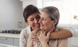 © peopleimages.com - Senior mom, woman and hug in family home for love, care and support in apartment. Female people, daughter and smile for mothers day in house with happiness, trust and together in lounge for relax