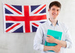 Young guy posing with notebooks against background of UK flag