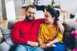 Portrait of male bearded handsome man sitting with his girlfriend jn comfortable sofa in modern designed apartments, young romantic couple spending free time together at home ,marrige enjoying leisure