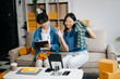 © Nuttapong punna - Fashion blogger concept, Two Asian women selling clothes on video streaming.Startup small business SME, using smartphone or tablet taking receive and checking.