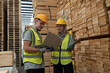 © amorn - Male and female warehouse worker working in lumber storage warehouse. Workers working in timber storage warehouse. Manufacturing and warehouse concept