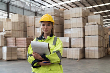 Portrait of female warehouse worker working in wooden warehouse storage. Female construction worker at wooden warehouse