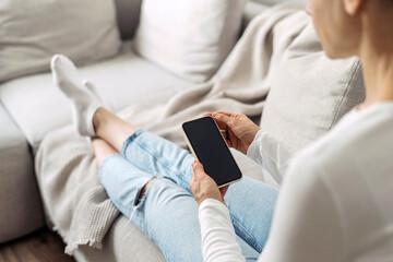Woman using online app at smartphone with empty display