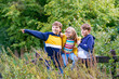 Three siblings children. Two kids boys and little girl having fun together on nature