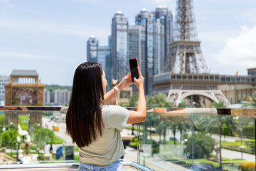 Poster - Tourist woman use mobile phone to take photo in Macau city