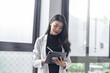 © Charlie's - Beautiful asian doctor Education profession doctor in white uniform gown coat Professional medical doctor with tablet at seminar or hospital wellness center