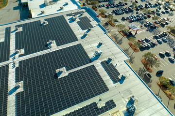 Wall Mural - Production of sustainable energy. Solar power plant with blue photovoltaic panels mounted on commercial shopping store building roof for producing green ecological electricity