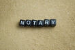 Concept of Notary written on wooden blocks. Cross processed image on Wooden Background