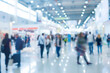 © Aisyaqilumar - A blurry image of an expo of convention lobby busy with people walking around.