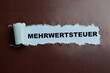 Concept of Mehrwertsteuer Text written in torn paper.