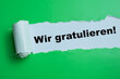 Concept of Wir Gratulieren Text written in torn paper.