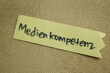 Concept of Medien Kompetenz write on sticky notes isolated on Wooden Table.