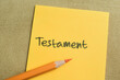 Concept of Testament write on sticky notes isolated on Wooden Table.