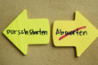 Concept of Durschstarten or Abwarten write on sticky notes isolated on Wooden Table.