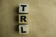 Concept of The wooden Cubes with the word TRL - Technology Readiness Level on wooden background.
