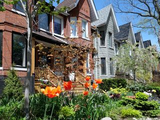 Sticker - Residential neighborhood with tall narrow houses with gables and garden with spring flowers