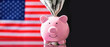 Pink piggy bank with US Dollar bills against flag of United States of America. Copy space.