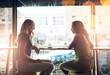 © peopleimages.com - Smile, window and women in cafe together for social meeting, business planning or networking. Remote work, partnership and girl friends in coffee shop with conversation, drink and happy connection.