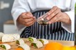 © BESTIMAGE - chef make tortilla wrap vegetable salad slice by knife on cutting board and mix sour salad dressing in small bowl glass with wine and olive oil. tortillas wrap vegetable and juicy liquid sour dressing