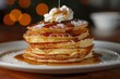A stack of pancakes with syrup and whipped cream on top