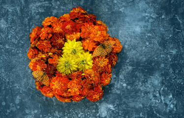 Poster - butterflies and floral mandala of orange flowers on abstract dark background. cempasuchil flowers - symbol of Mexico's Day of the Dead. esoteric spiritual ritual. top view