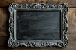 Aged chalkboard with ornate silver frame on wooden table