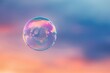 Delicate soap bubble floating in warm sunset light