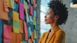 © Andrey - African American woman planning with sticky notes on glass wall in creative office. Modern workspace design concept