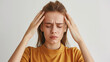 © amila - Young Woman Experiencing Headache against White Background, Headache Concept, Adult Female with Head Pain